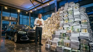 Geschäftsmann zwischen Luxusauto und Geldstapeln.